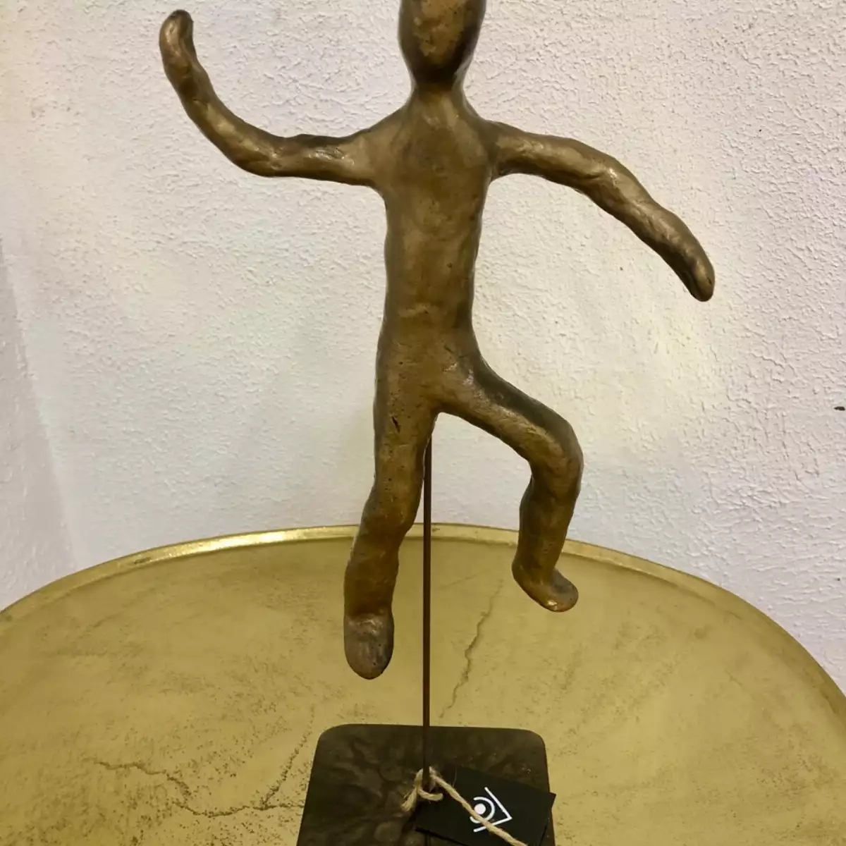 Homme en argile or et noir sur pied en résine , sculpture
