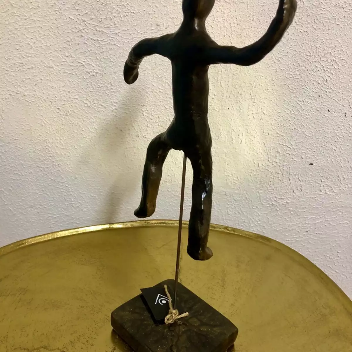 Homme en argile or et noir sur pied en résine , sculpture
